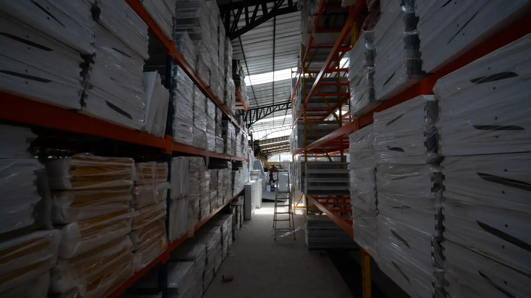 Pasillo de racks con producto embalado en la bodega de Hypermetales