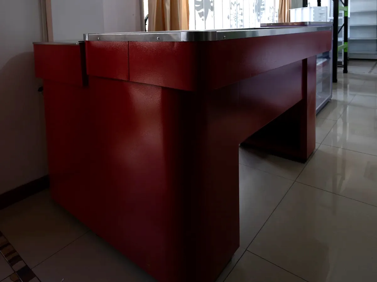Punto de pago de ventanilla en color vino con superficie de atención amplia