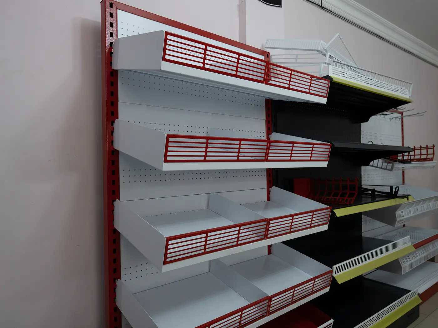 Góndola metálica blanca y roja con entrepaños y canastillas